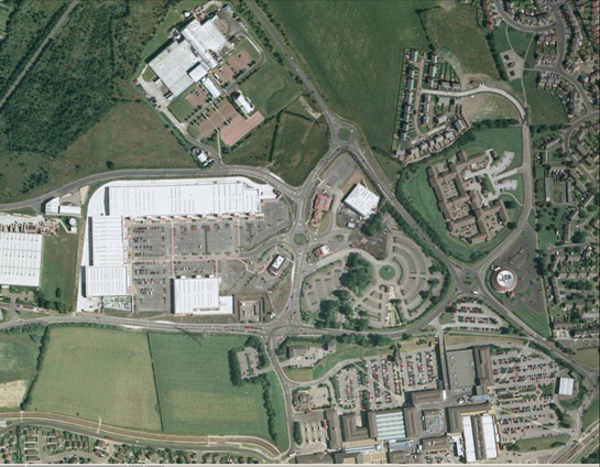 Text Box: Figure 2: The massive developments of Crystal Peaks and Drakehouse are typical of late 20th century centralised retail, with their use of large prefabricated warehouse buildings, dedicated transport nodes, and above all their enormous car parks. Historic legibility is rejected in favour of modern efficiency. Aerial Photograph © 1999 Geoinformation Group.